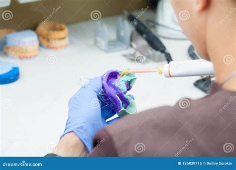 Dental Technician Works With A Cast Of Teeth In The Laboratory Stock