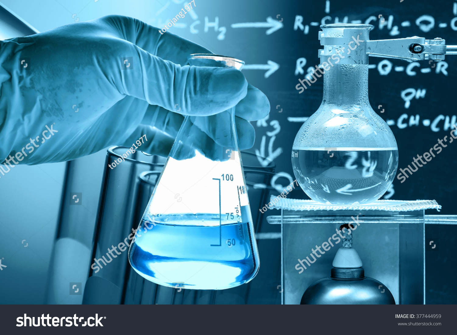 Flask In Scientist Hand With Laboratory Background Stock Photo