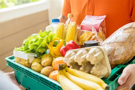 Grocery Store Delivery Man Delivering Food To A Customer At Home Stock