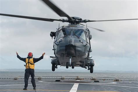 Smooth Landings A Flight Deck Officer Guides An Nh90 Helicopter In On